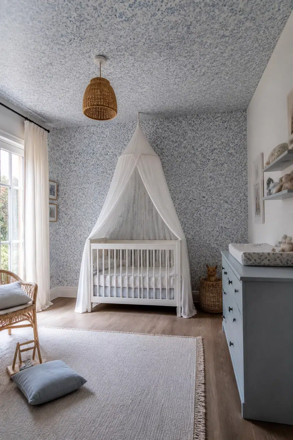 Blue floral nursery wallpaper covering walls and ceiling with white canopy crib and rattan pendant light.