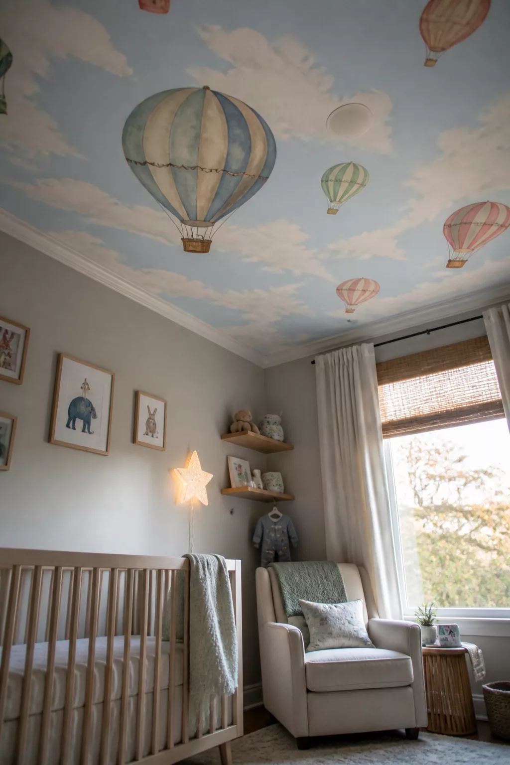 Hot air balloon nursery ideas with a painted sky ceiling mural featuring colorful watercolor balloons and clouds.