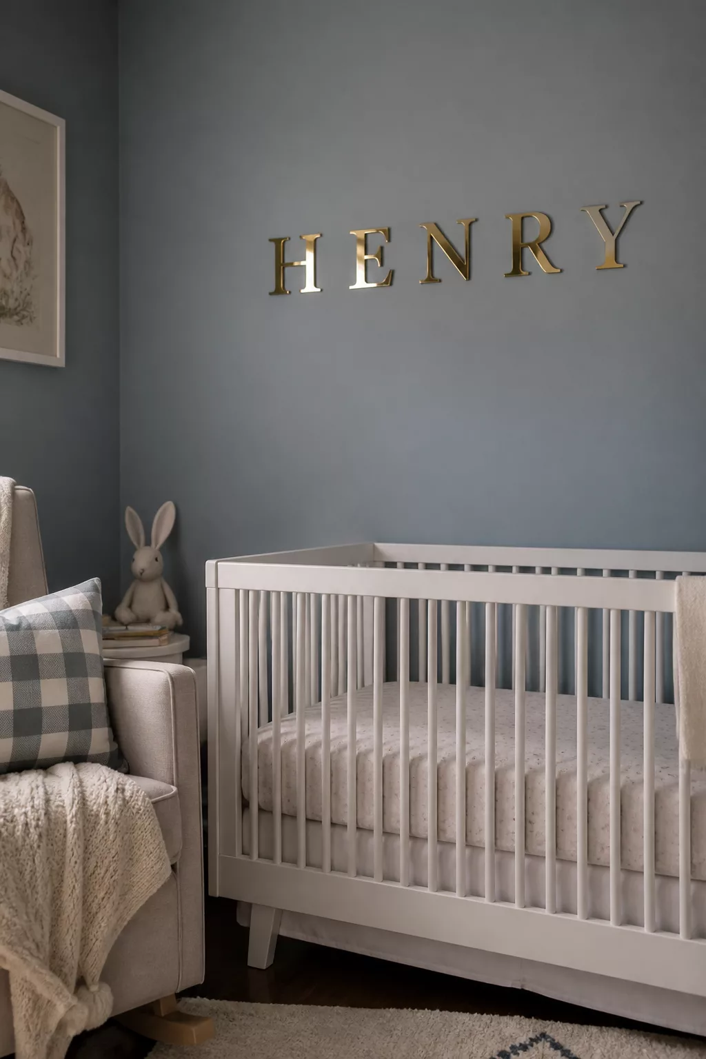 Gold mirror nursery name sign spelling HENRY above a white crib on a dusty blue wall — nursery name signs idea.
