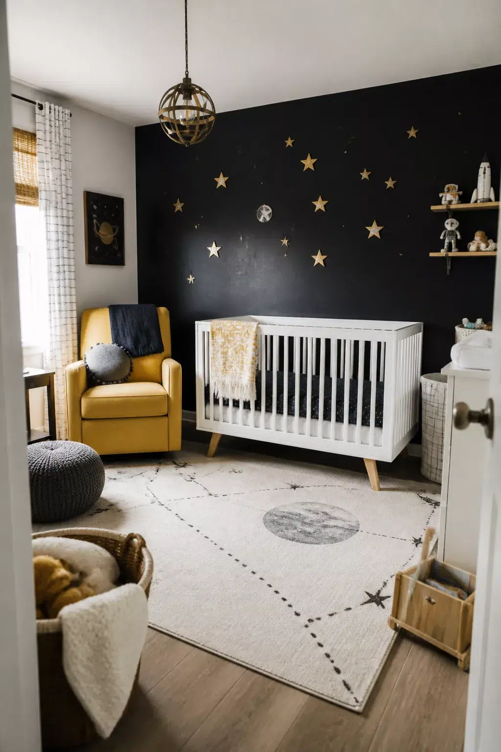Space themed nursery ideas featuring a matte black accent wall with gold star decals, white crib, and mustard glider.