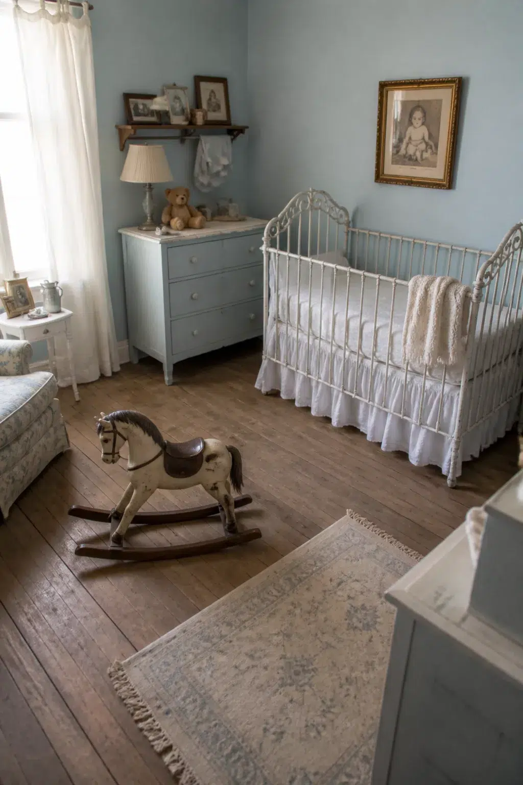 Dusty blue Victorian vintage nursery ideas with antique iron crib, rocking horse, and painted dresser