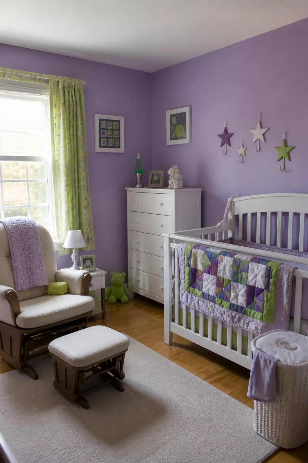 Purple and green 90s nursery with lavender walls, star wall hooks, patchwork crib quilt, and glider rocker