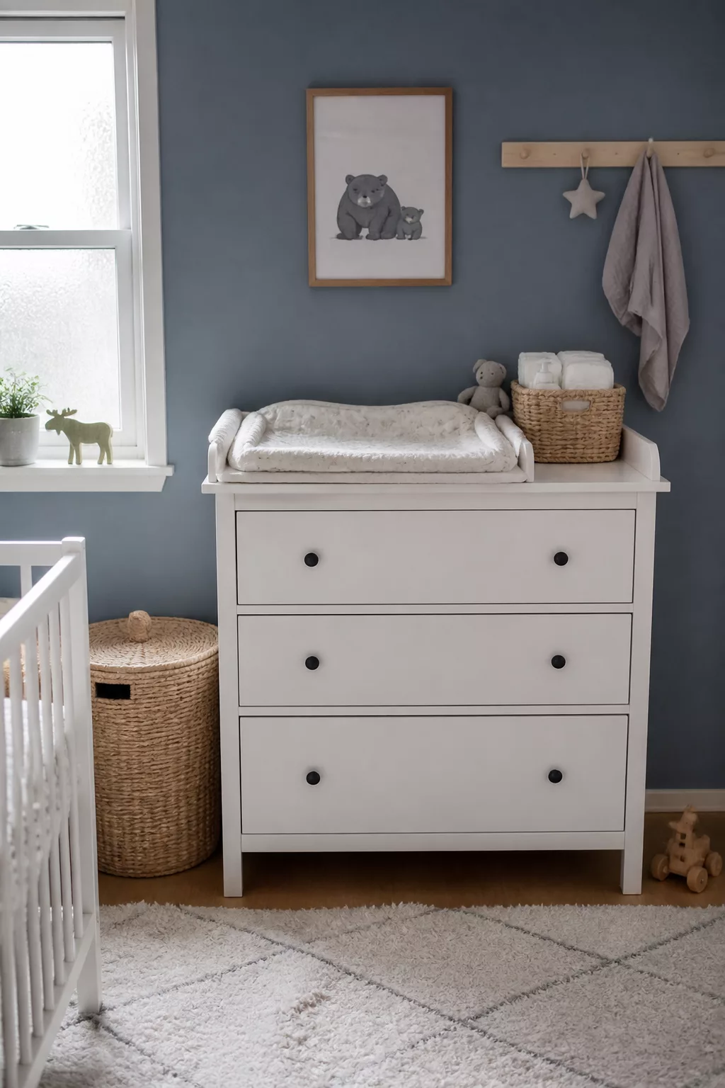 IKEA nursery with HEMNES dresser as changing table, slate blue walls, bear print art, and woven baskets
