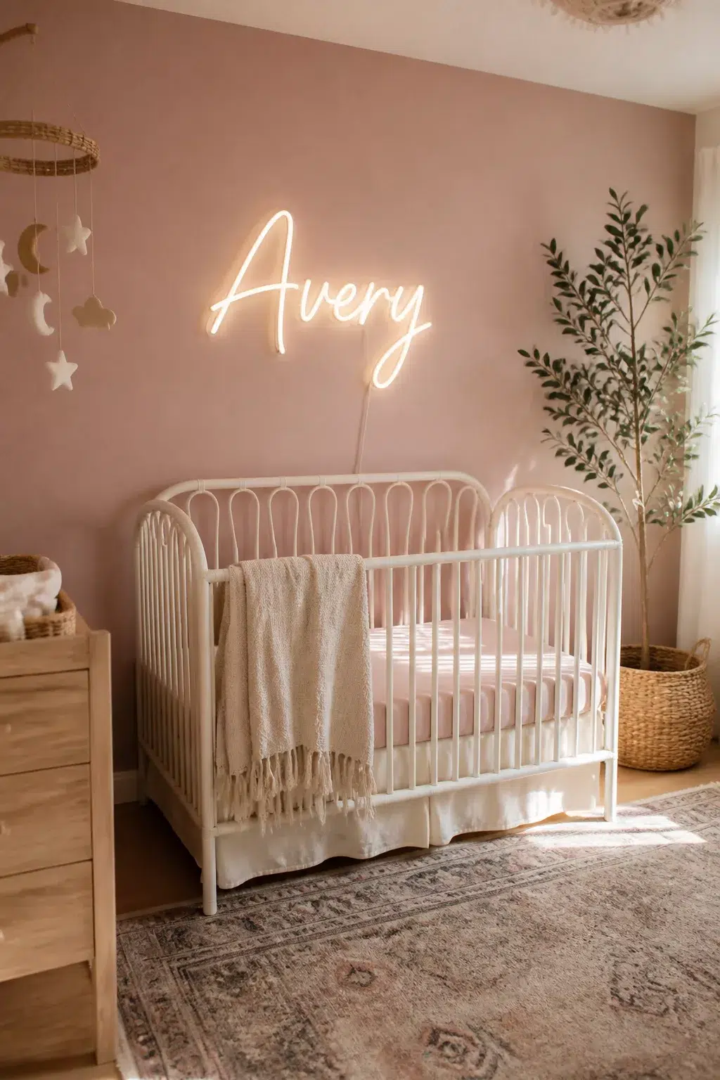 Warm white neon name sign above iron crib — nursery wall name ideas with a boho pink accent wall
