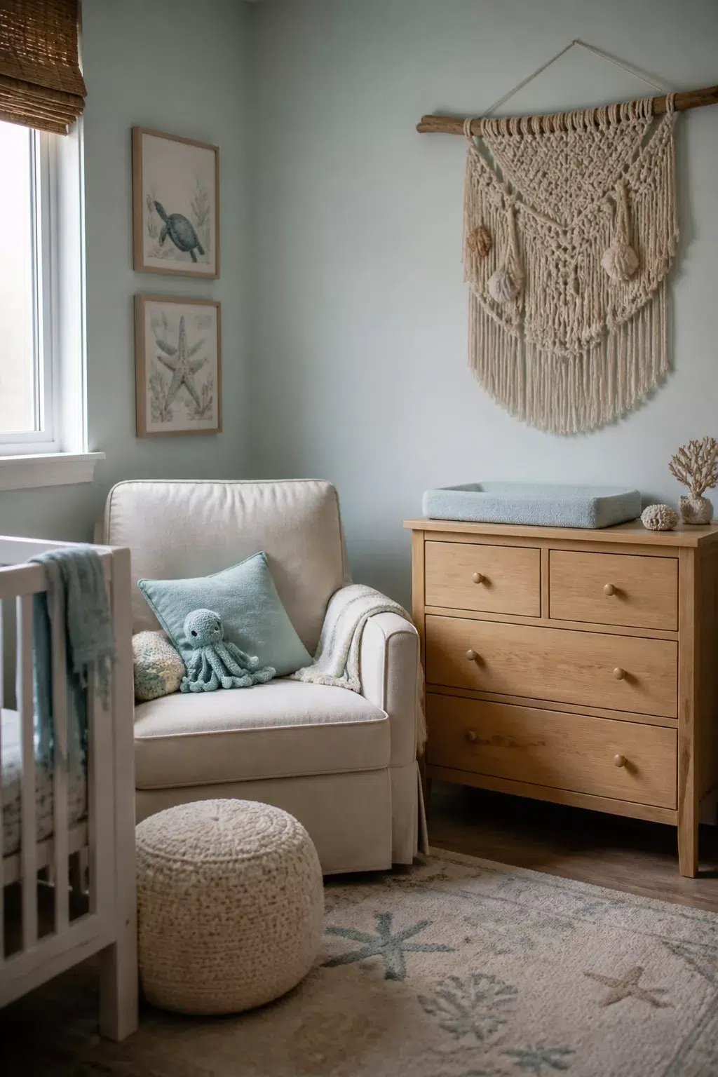 Under the sea nursery idea with driftwood macramé wall hanging, cream glider, and ocean art prints